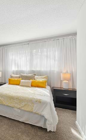 A bedroom with a bed, nightstands, and pictures on the wall. at Emory Woods, Durham, 27713