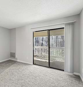 A room with a sliding glass door leading to a balcony. at Emory Woods, North Carolina, 27713