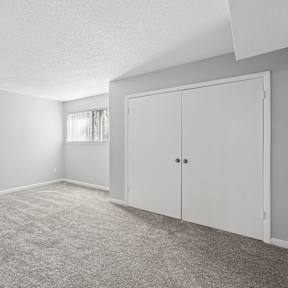 A room with a carpeted floor and a white door. at Emory Woods, Durham, 27713
