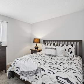 A bedroom with a bed, nightstand, and dresser. at Emory Woods, Durham, NC