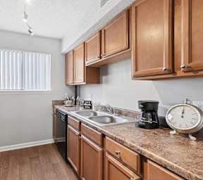 A kitchen with wooden cabinets and a granite countertop. at Emory Woods, North Carolina