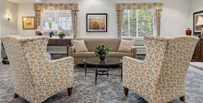 A living room with two chairs and a sofa.
