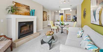 A living room with a fireplace and a painting on the wall.