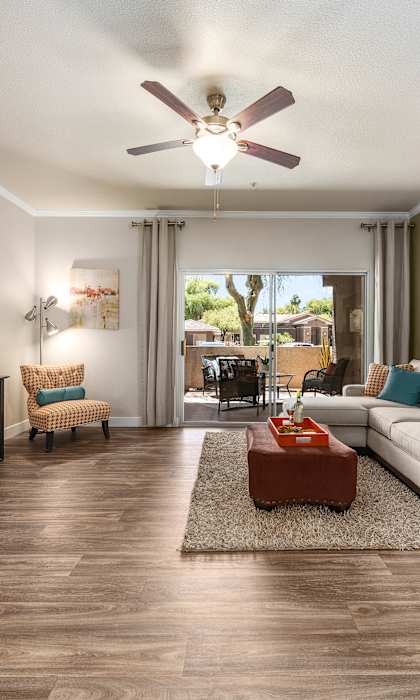 A living room with a white couch and a brown rug.