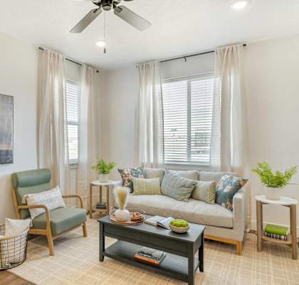 a living room with a couch and a ceiling fan
