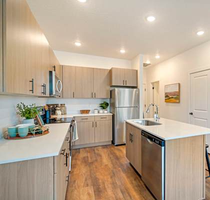 A modern kitchen with wooden cabinets and stainless steel appliances.