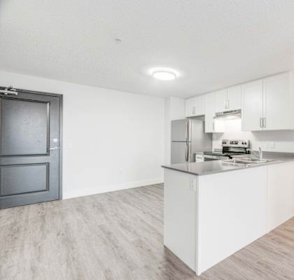 A kitchen with a white island and wooden floors.
