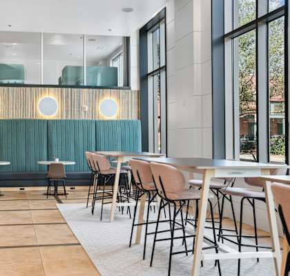 a dining room with tables and chairs and a staircase