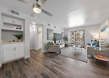 A living room with a grey sofa and a glass coffee table.