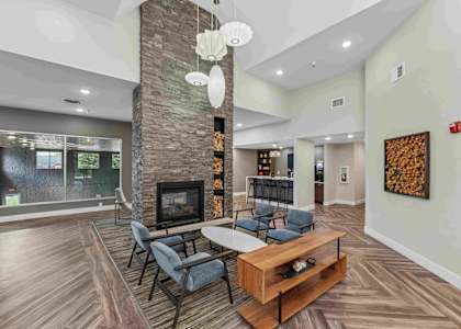A modern living room with a stone fireplace and a wooden coffee table.