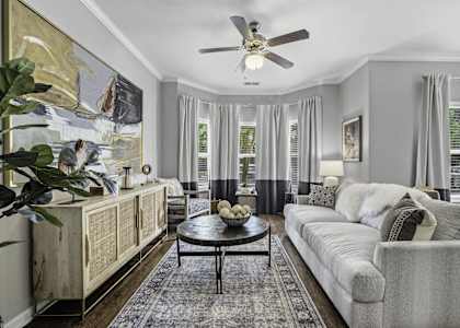 A living room with a grey couch and a wooden cabinet.