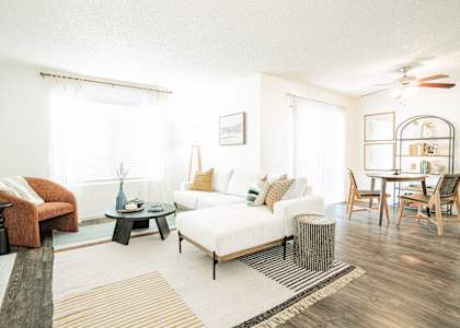 a living room with a white couch and a dining room table