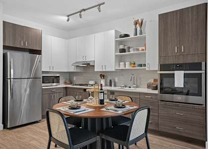 A modern kitchen with a table set for two.
