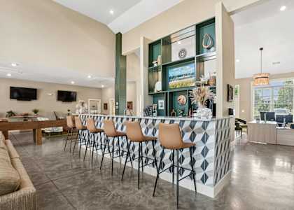 a large lobby with a bar and a living room with furniture