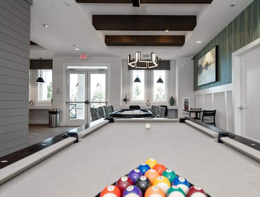 a pool table in a living room with a bunch of balls on it