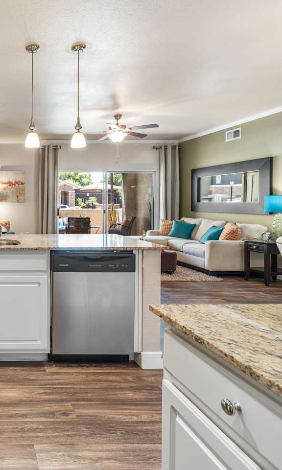 A kitchen with white cabinets and a granite countertop.