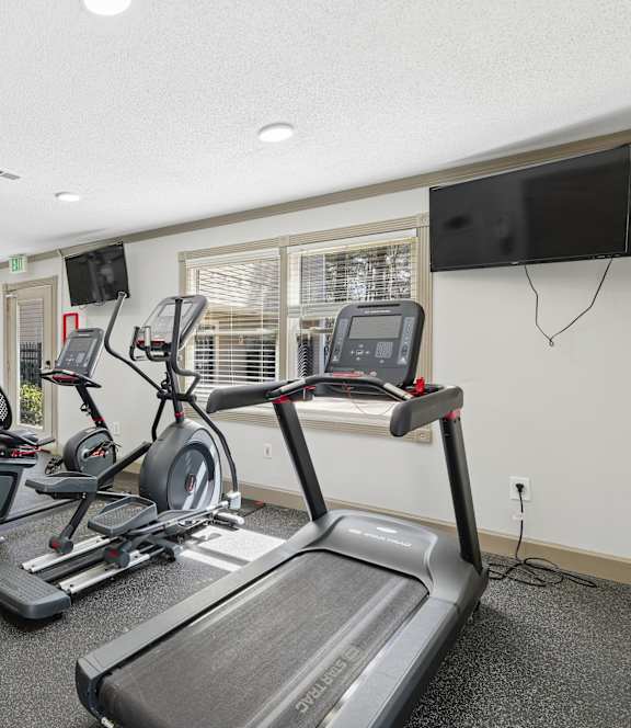 A spacious gym with treadmills, weights, and exercise equipment. at Emory Woods, Durham