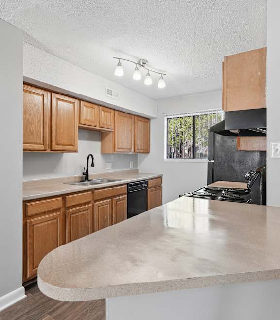 A kitchen with wooden cabinets and a beige island. at Emory Woods, Durham North Carolina