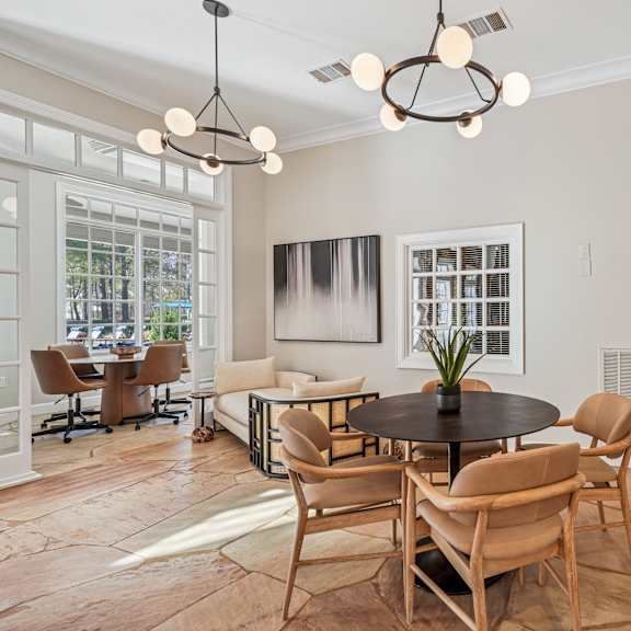 A modern dining room with a round table and chairs.