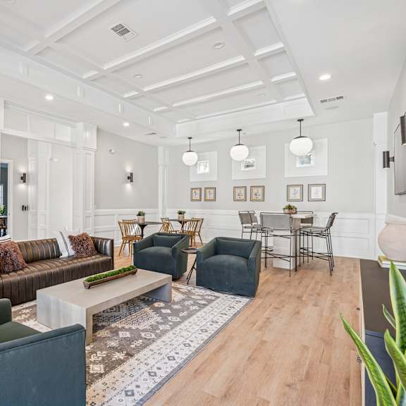 A living room with a white ceiling and a rug on the floor.
