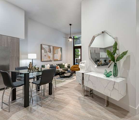 A modern dining room with a marble bench and a large mirror.