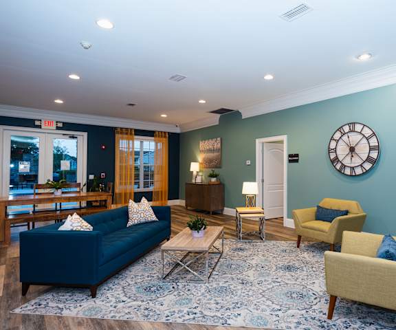 a living room with blue furniture and a clock on the wall