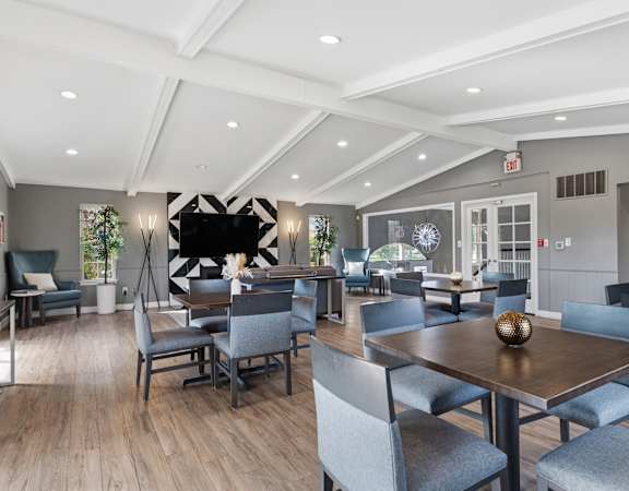 A modern dining room with a wooden table and grey chairs.