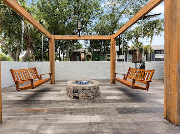 a fire pit in the middle of a patio with benches