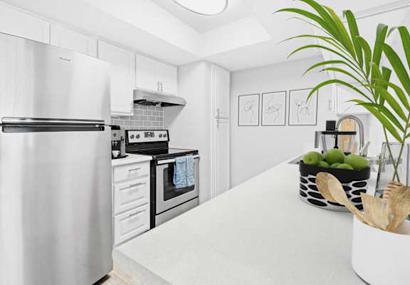 a white kitchen with stainless steel appliances and a white counter top