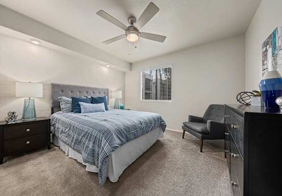 a bedroom with a bed and a ceiling fan