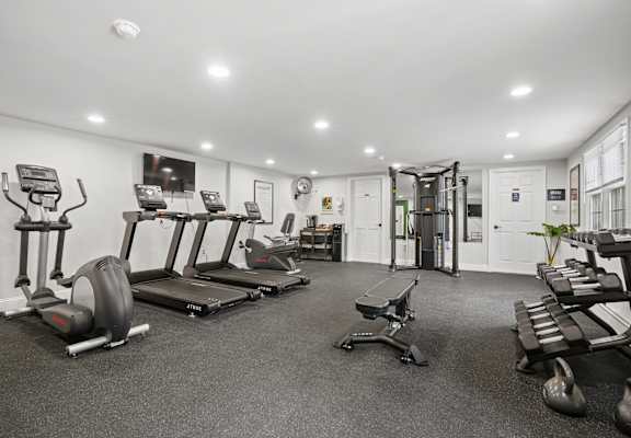 A spacious gym with treadmills, elliptical machines, and other exercise equipment.