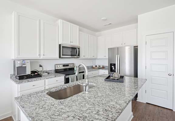 A kitchen with granite countertops and white cabinets.