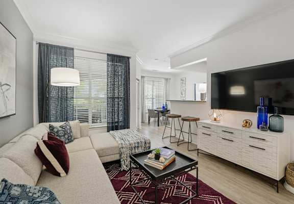 A living room with a white couch and a black coffee table.