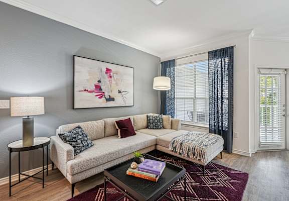 A living room with a couch, a table, and a painting on the wall.
