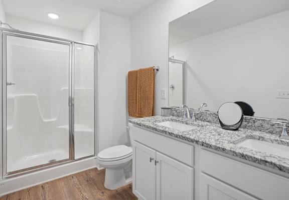 A bathroom with a toilet, sink, and shower.