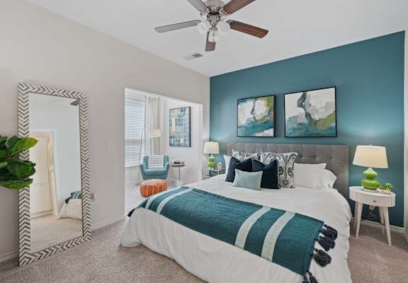 A bedroom with a large bed and a mirror on the wall.