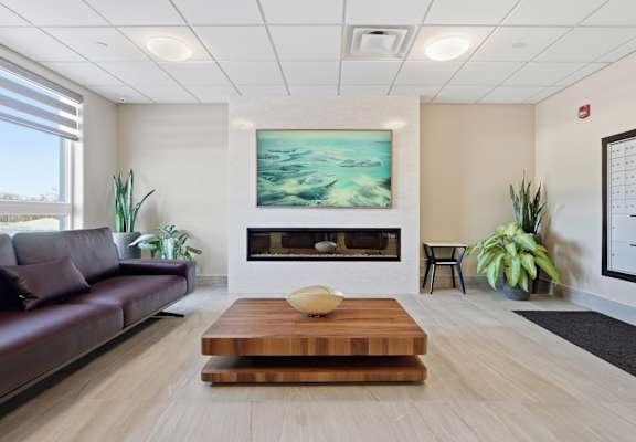 A modern living room with a fireplace and a painting on the wall.