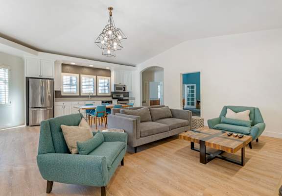 A living room with a grey couch and a green armchair.
