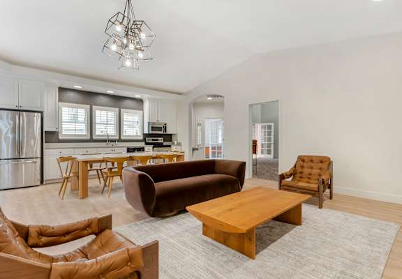 A modern living room with a brown leather sofa and a wooden coffee table.