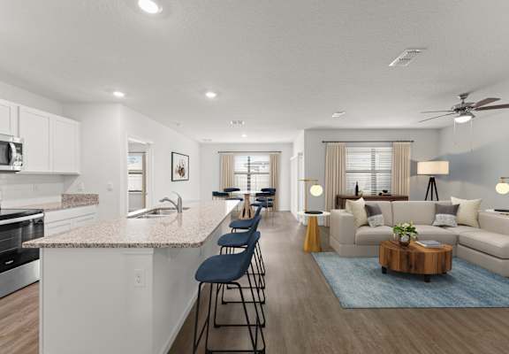 A modern kitchen with a bar area and a living room with a couch.