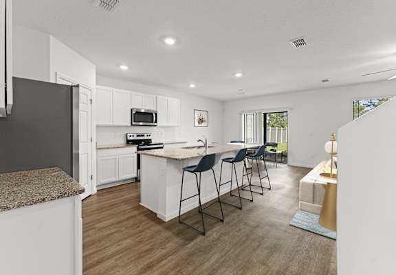 A modern kitchen with white cabinets and a central island.