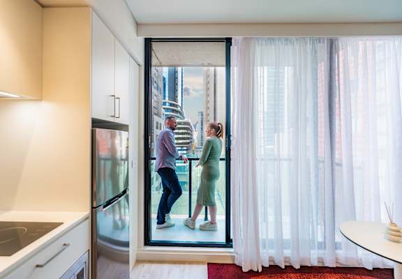 a man and a woman are standing in a glass door
