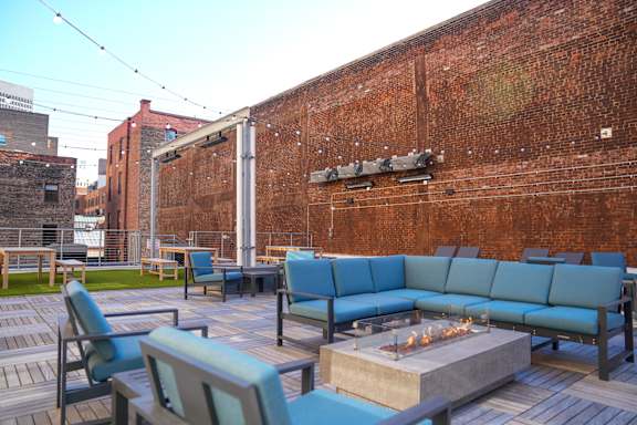 A patio with blue couches and a fire pit.at East 4th Street, Cleveland, OH
