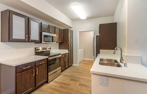 A modern kitchen with a white island and stainless steel appliances.