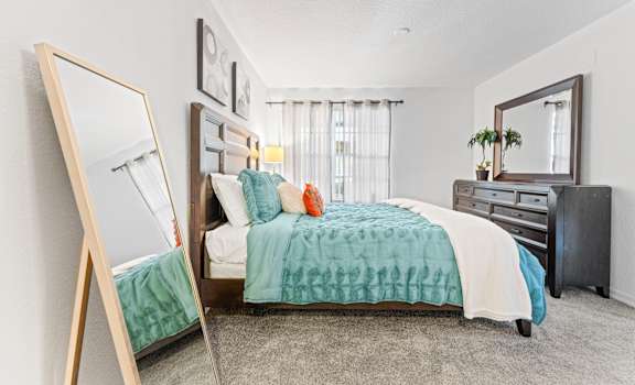a bedroom with a bed and a mirror