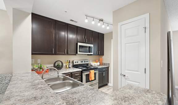 A kitchen with brown cabinets and a white door.