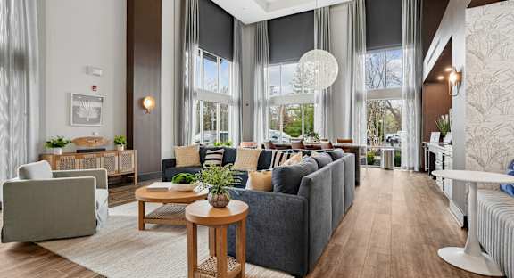 A modern living room with grey couches and wooden furniture.