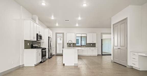 A spacious kitchen with white cabinets and a central island.