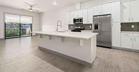 A modern kitchen with white cabinets and a large island.