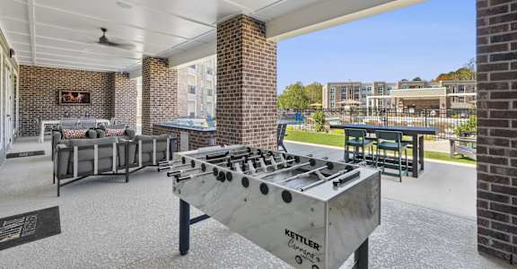 A Kettler outdoor grill is in the foreground of a patio area.